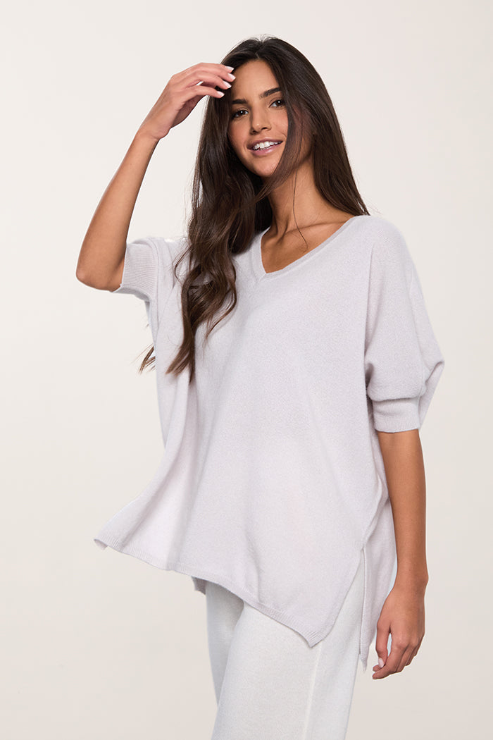 Maxi maglia con scollo a V, manica corta e spacchi laterali in puro cashmere colore ghiaccio.
